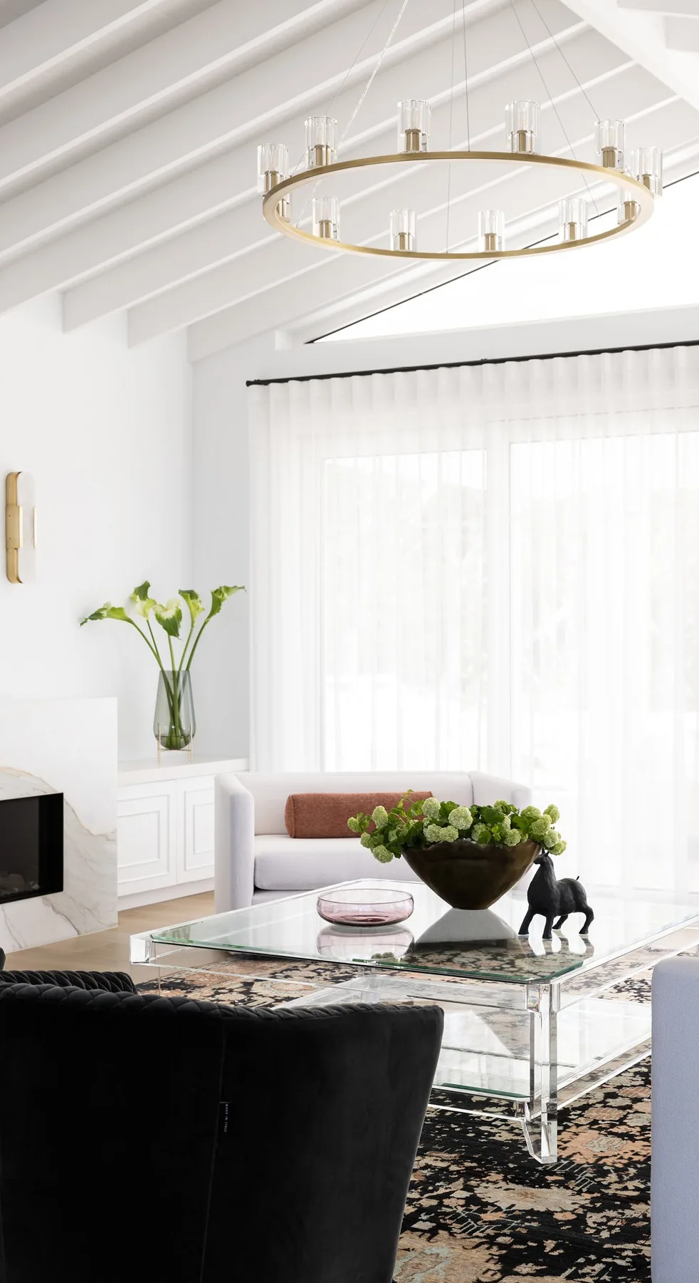 Elanora &mdash; living room corner with brass ring chandelier and sheer curtains