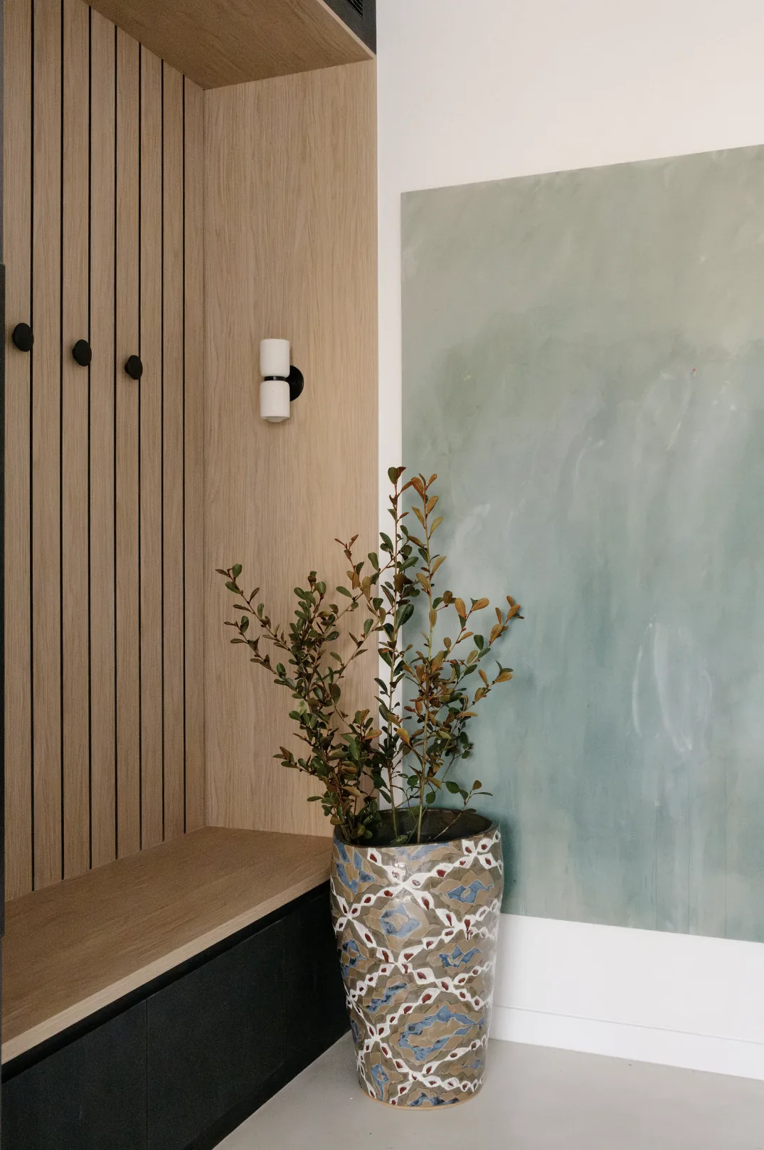 Freshwater &mdash; entry joinery with oak slats, bench seat and soft sage feature wall