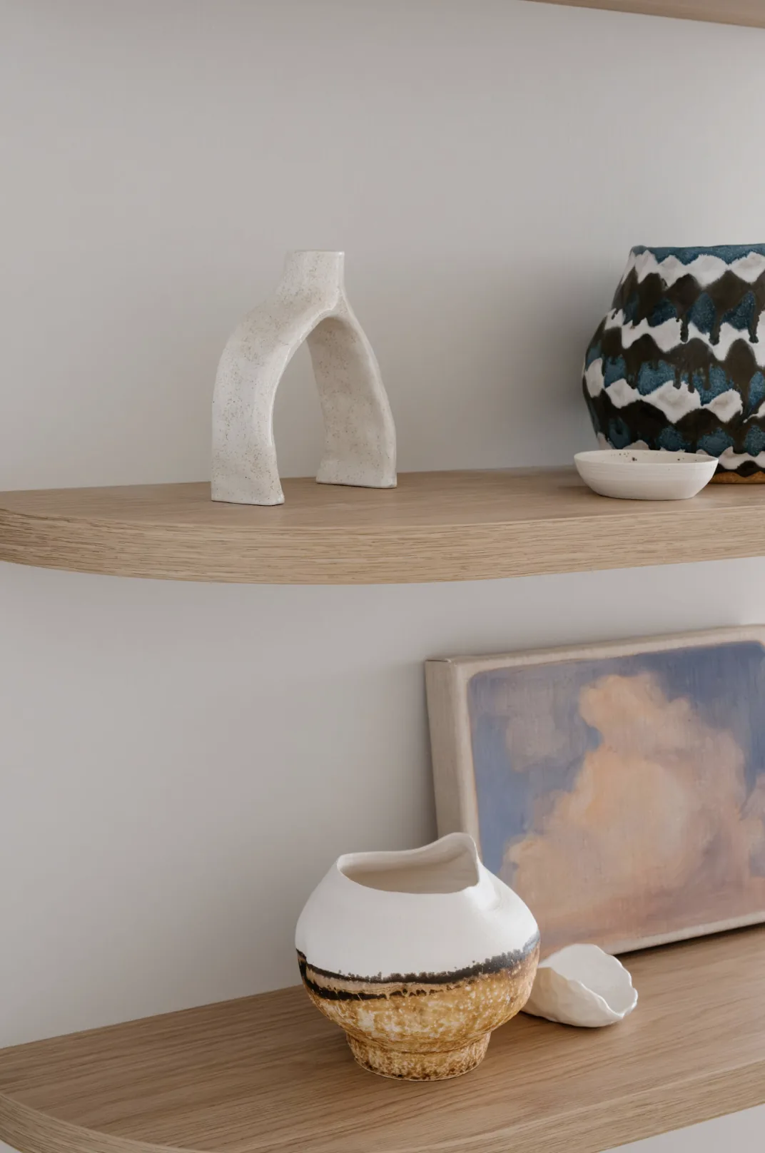 Freshwater &mdash; curved timber shelves styled with ceramics and a sky-toned painting