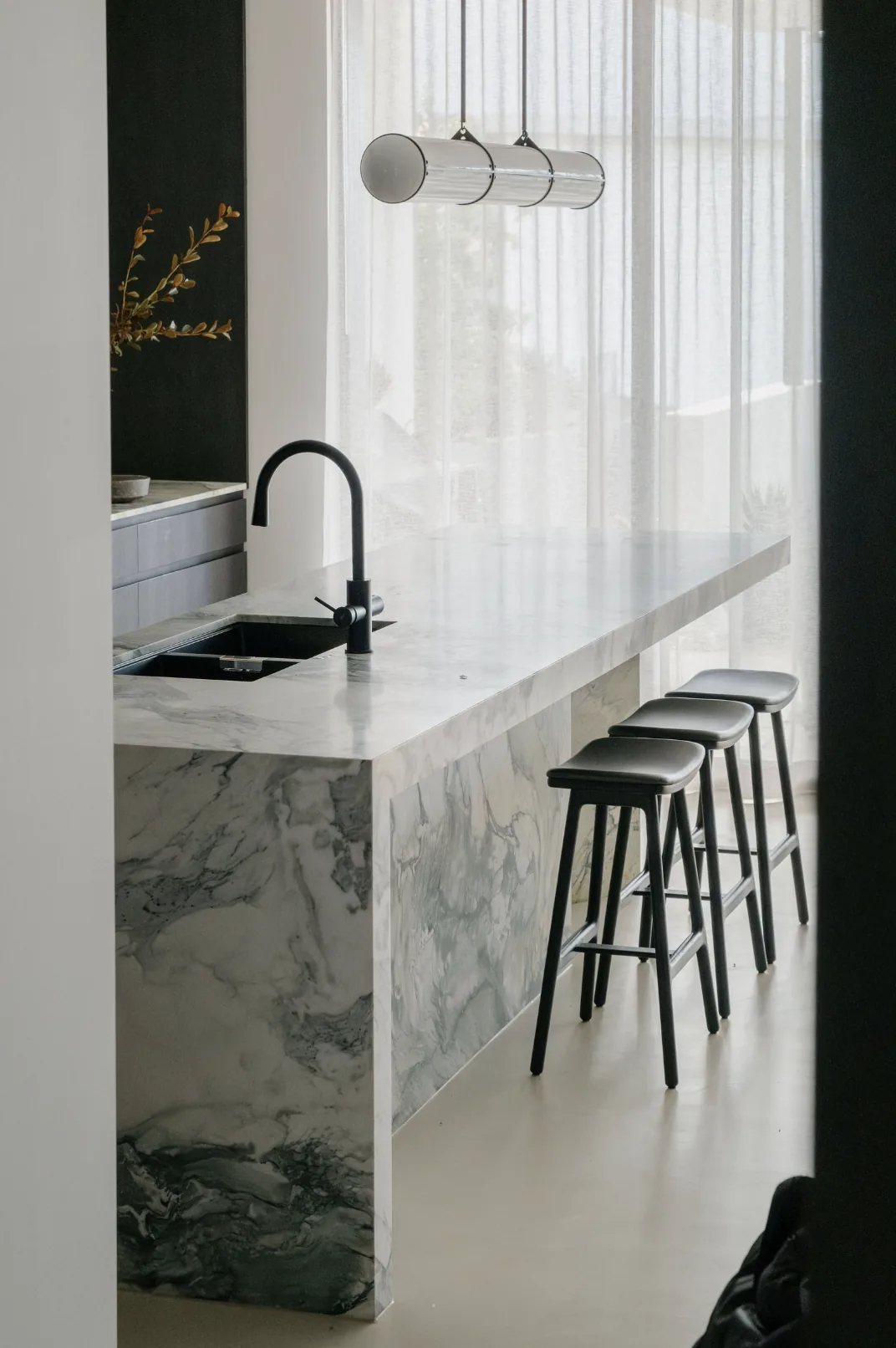 Freshwater &mdash; marble island with black stools and pendant lights viewed from the dining area