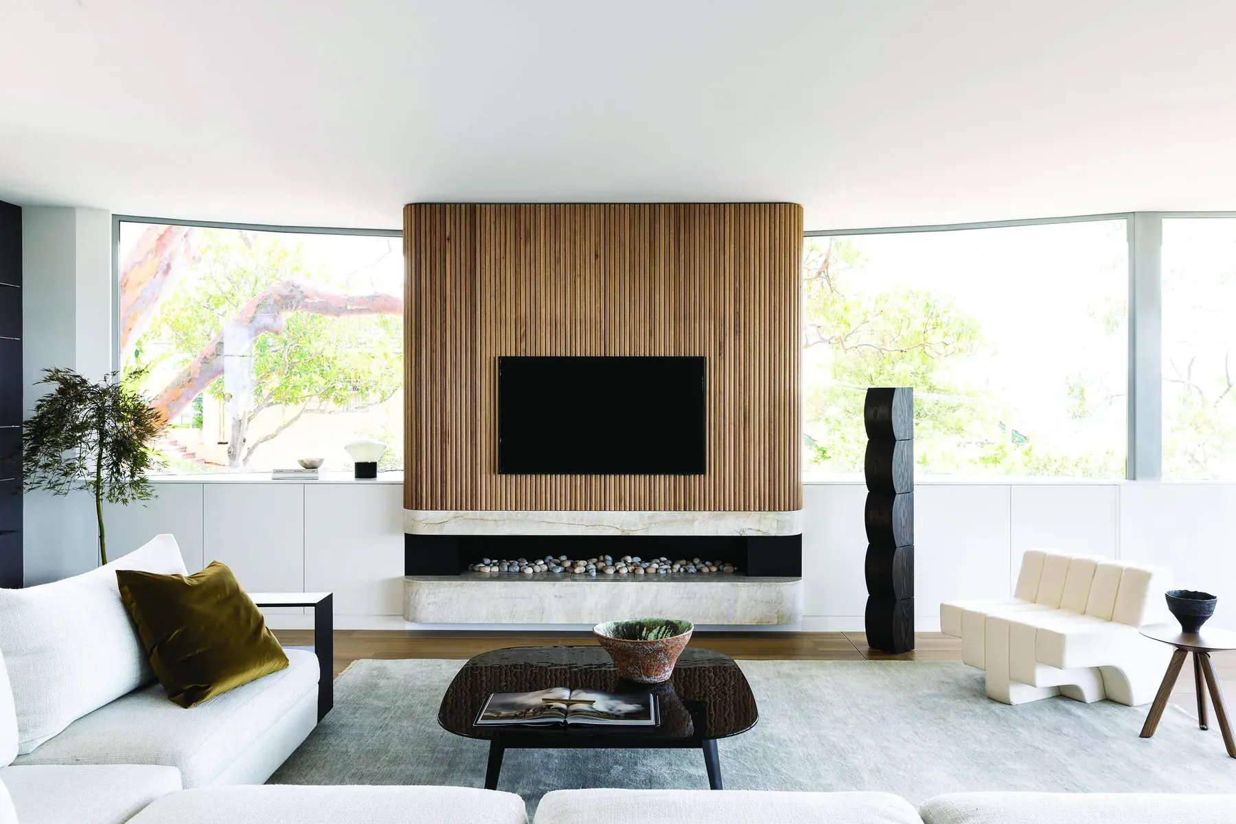 Mosman 02 &mdash; living room with timber feature wall, white sofa and curved glass windows