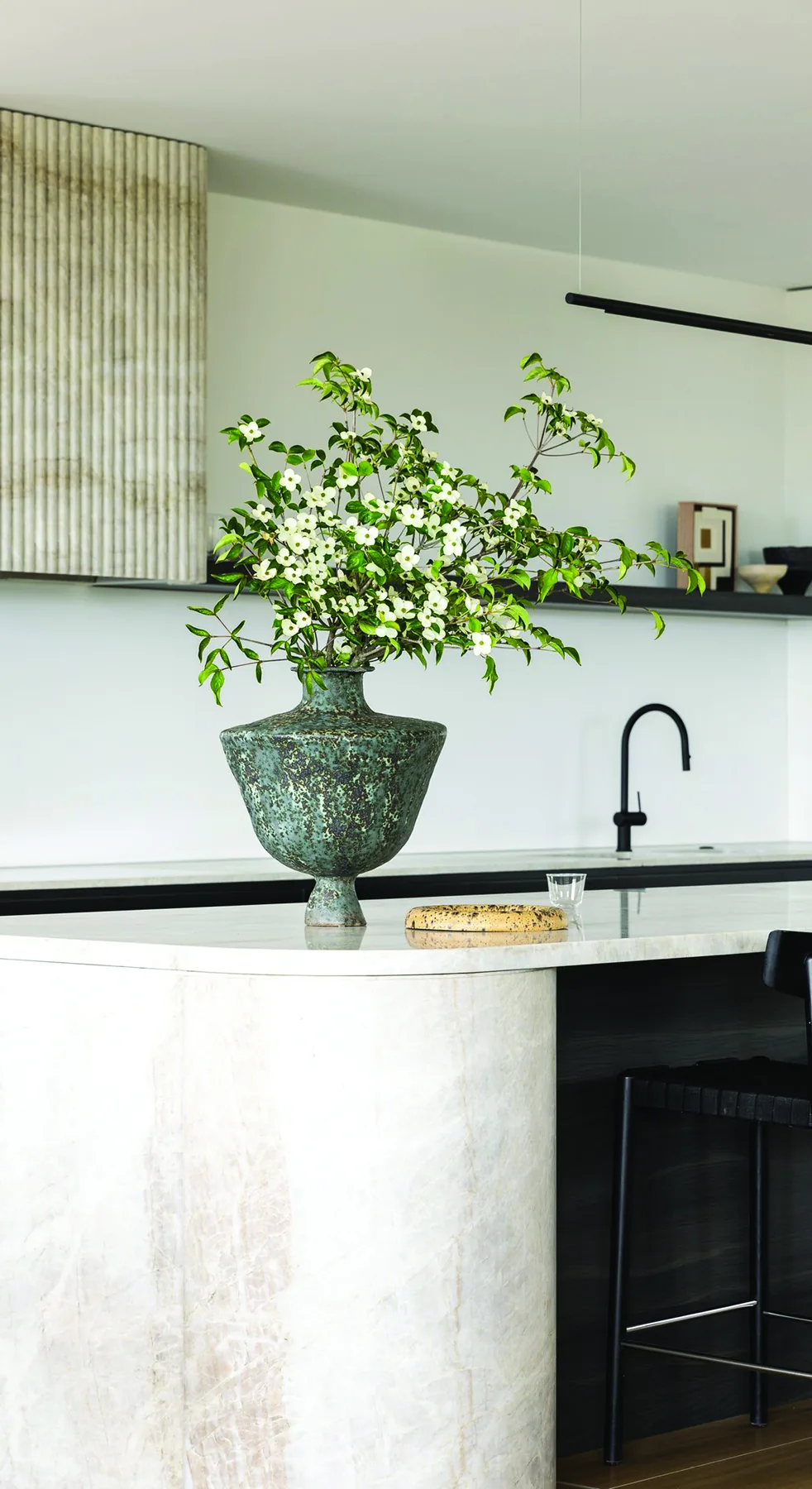 Mosman 02 &mdash; kitchen island in pale stone with a fluted stone rangehood