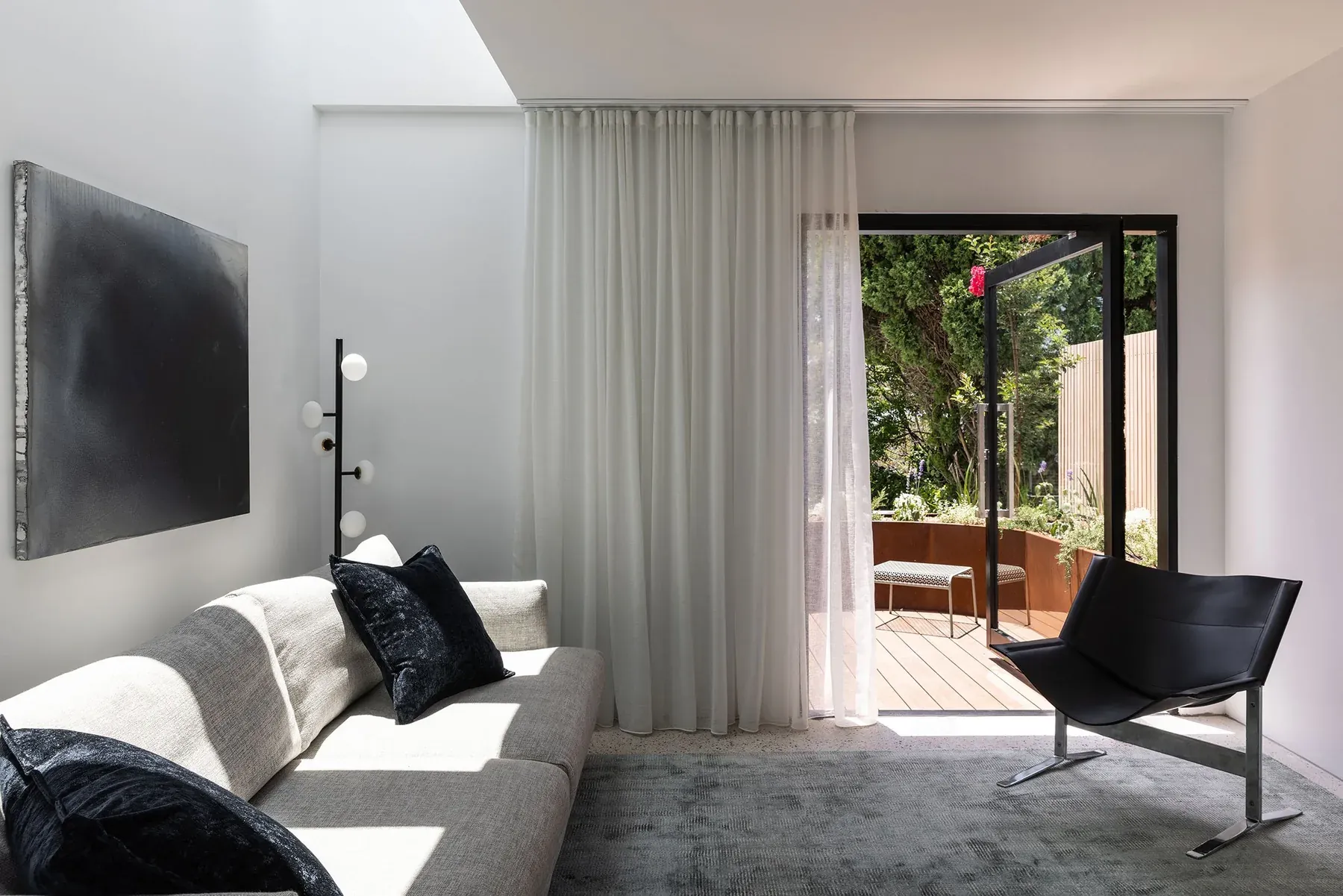 North Sydney &mdash; living room with sheer curtains opening onto a timber deck courtyard
