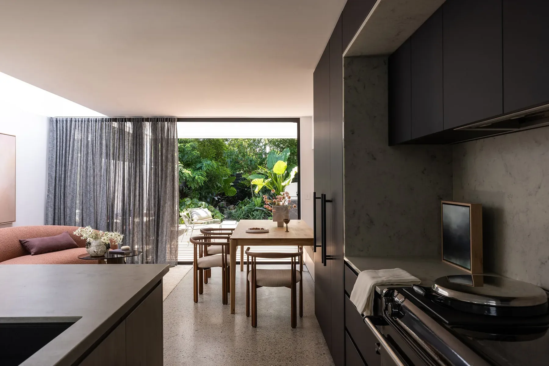 North Sydney — black kitchen opening to the living and dining space and courtyard