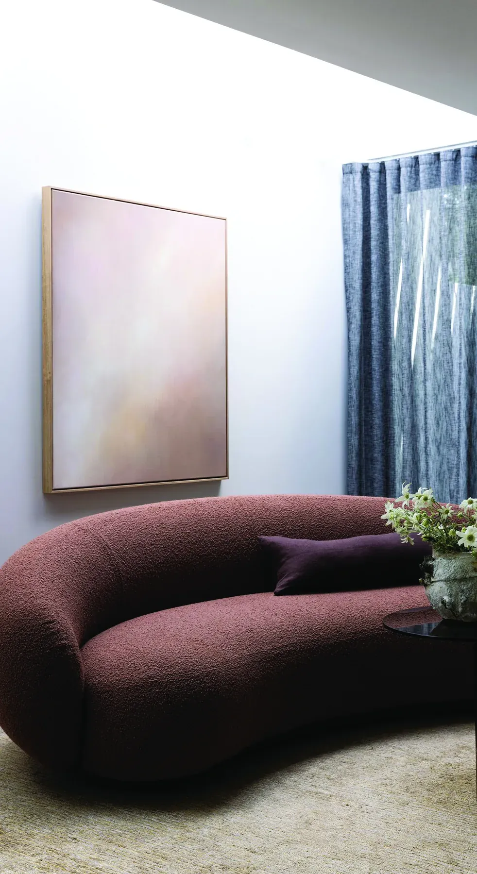 North Sydney &mdash; burgundy curved sofa beneath a soft pink abstract painting