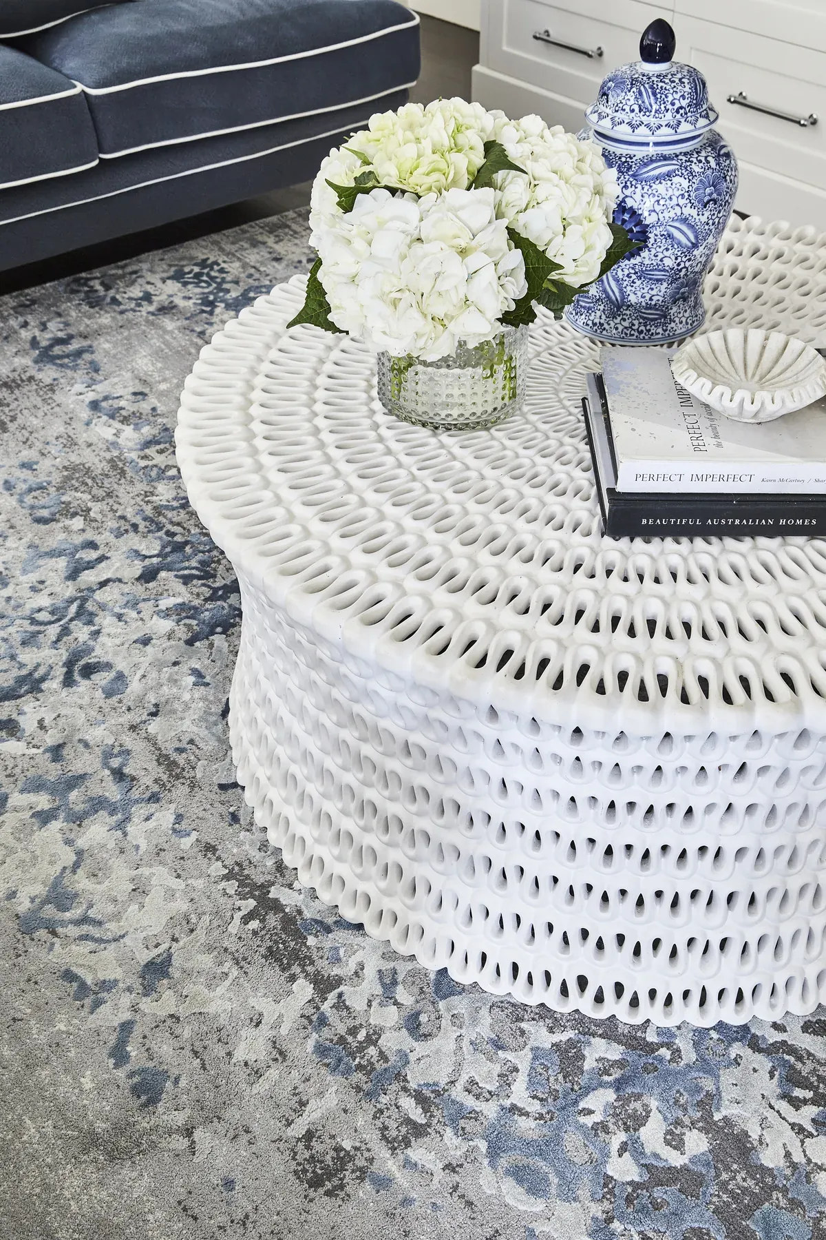 Wahroonga — woven white coffee table styled with hydrangeas and a blue-and-white jar